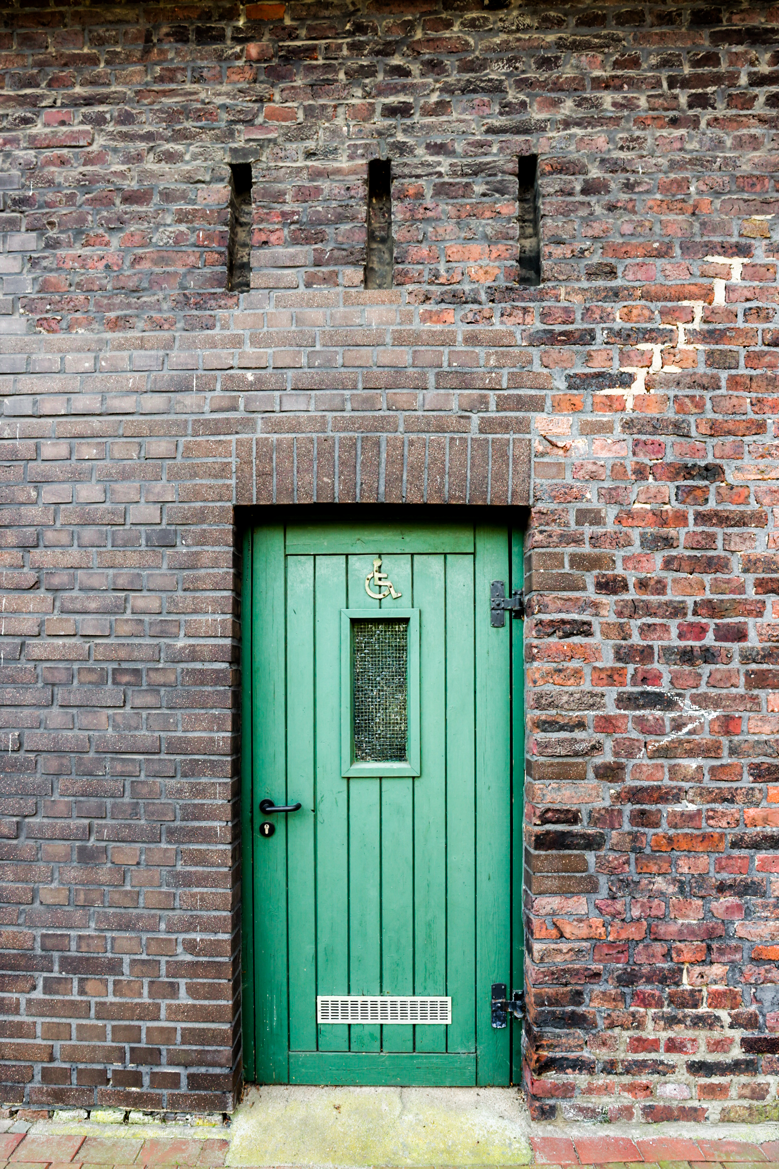 Grüne Eingangstür zum Behinderten-WC am Reiterhof Alsbachtal