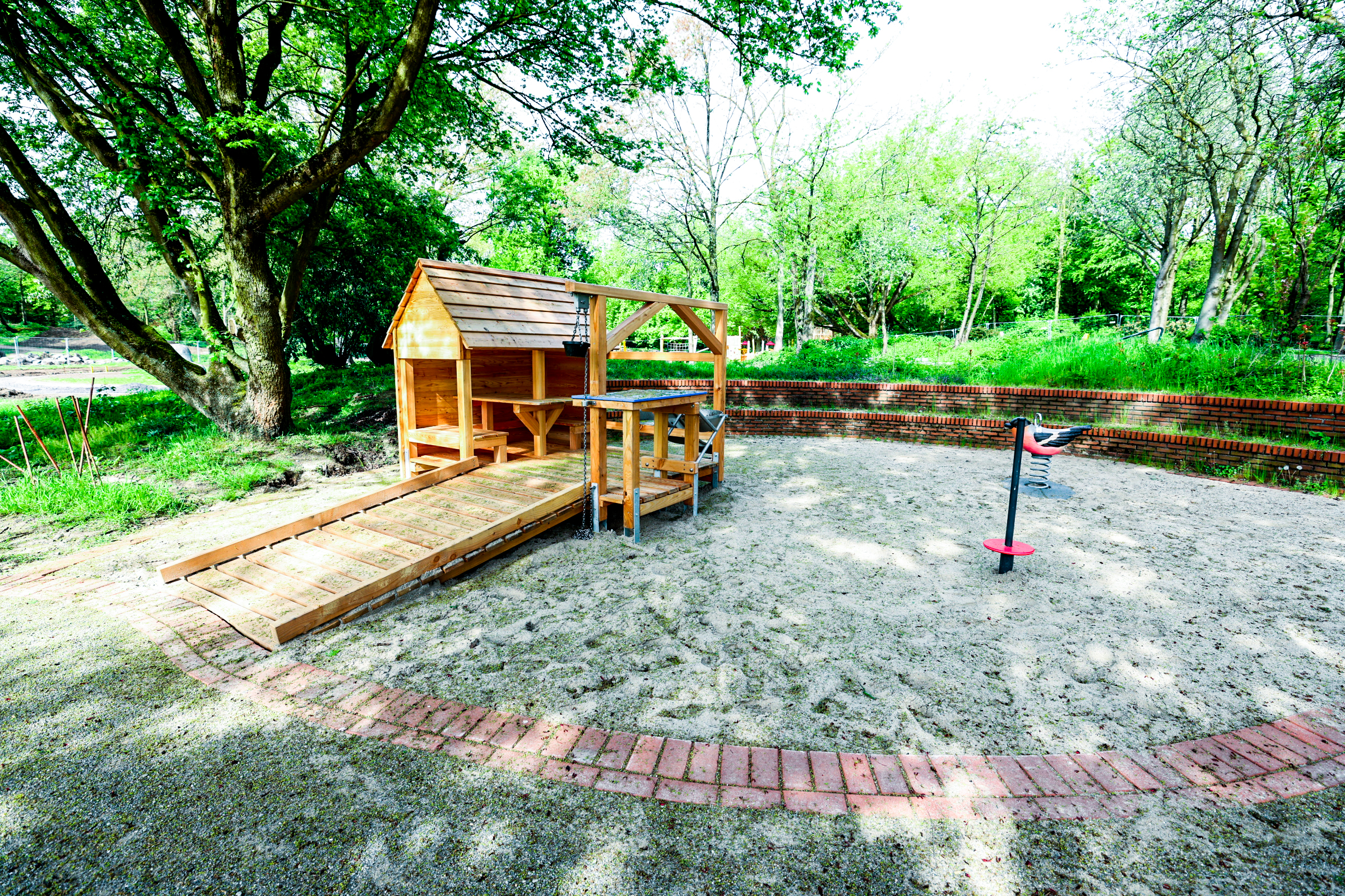 Spielhaus aus Holz mit barrierefreiem Zugang auf Kinderspielplatz